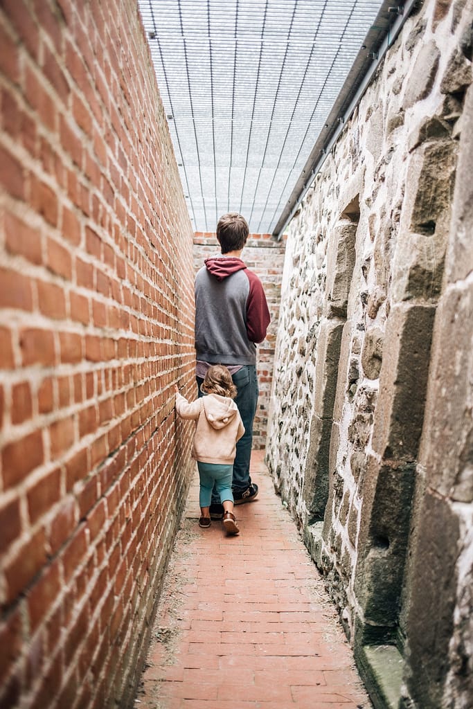 Family with young kids exploring inside Fort Anne