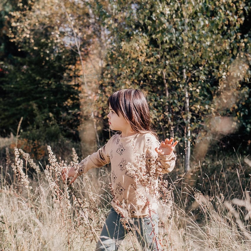 Girl explores through long grassy field in Nova Scotia